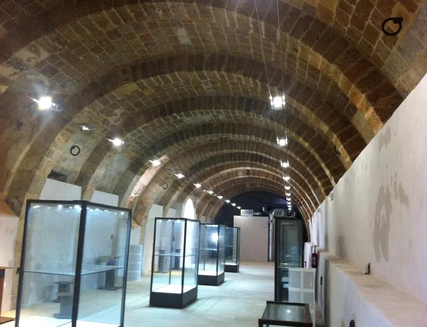Ambiente storico con volte a botte restaurate e allestimento museale con vetrine
